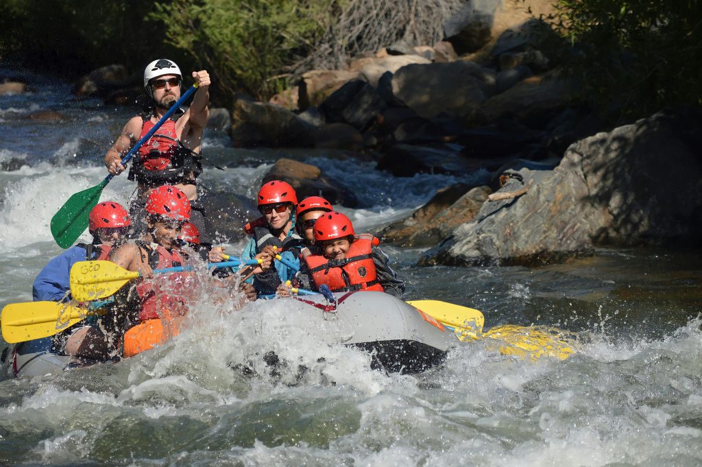 Group enjoying a thrilling whitewater rafting experience on a rapid river.